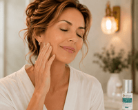 Thumbnail for A woman with closed eyes and a serene expression touches her cheek, wearing a white robe in a softly lit spa-like setting. A small skincare bottle is visible in the lower right corner.