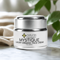 Thumbnail for A jar of Nature's Skin and Body Mystique Luxury Organic Face Cream sits on a marble surface with a soft beige cloth and green leaves blurred in the background.